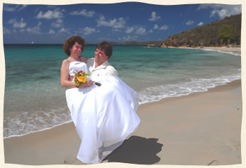 Groom scooping up bride after getting married on Bluebeards Beach