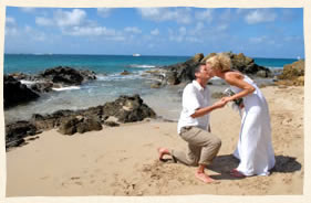 Beach bride kissing the groom by the Caribbean Sea.