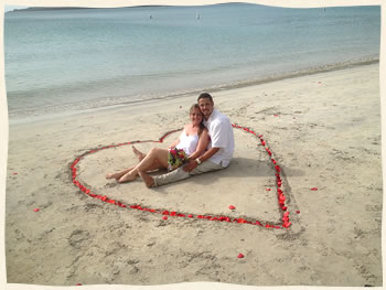 happy couple in rose petal heart on St. Thomas beach
