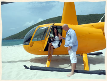 Bride getting out of helicopter to her private island beach wedding.