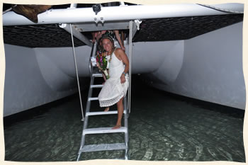Bride stepping off boat ladder after wedding at sea.