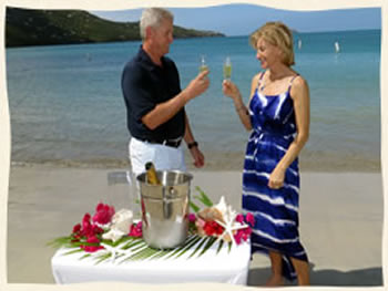 Couple toasting to 20 years of marriage after renewing their vows on tropical beach in St. Thomas.