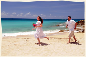 Island groom catching up to his island bride on Bluebeards Beach in St. Thomas USVI