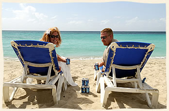 Caribbean wedding couple on lounge chairs.