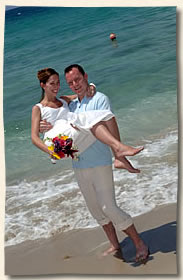 Island wedding groom swooping up bride.