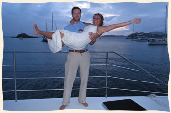 Groom lifting bride after sailboat wedding.